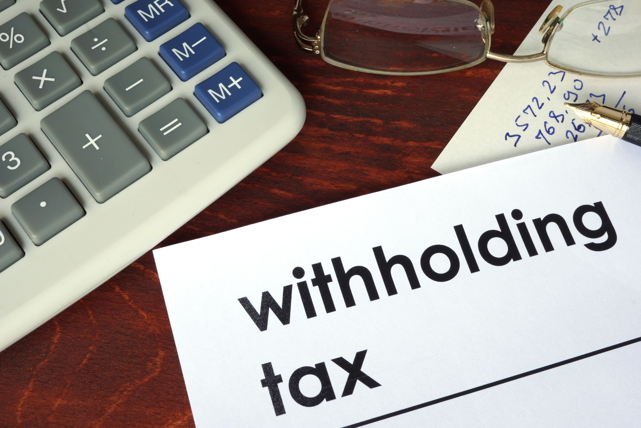 Withholding tax written on a paper Withholding tax written on a paper
